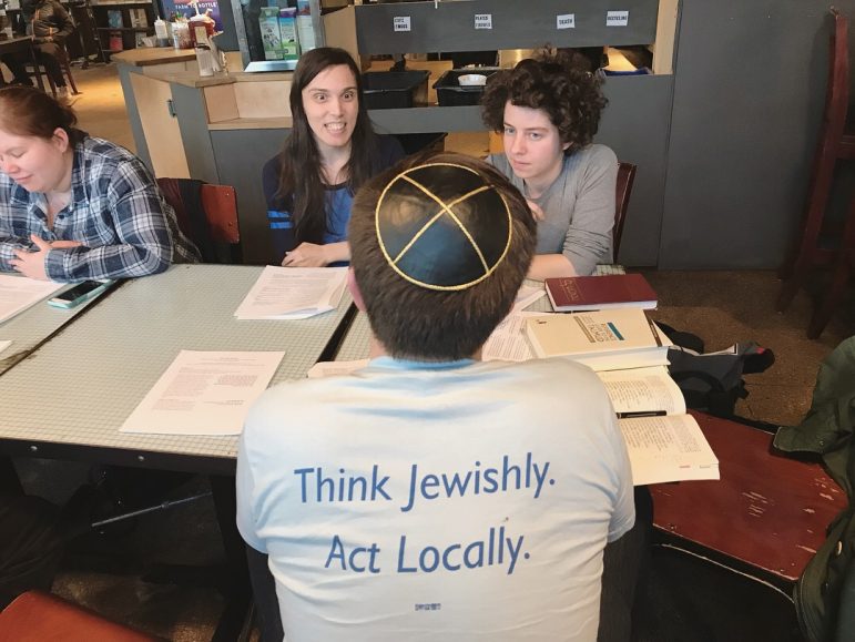 people at a table talking, one of the people is wearing a JUFJ shirt