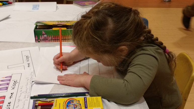 a child drawing on a piece of paper